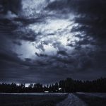 Dirt Road In A Field Under A Cloudy Sky