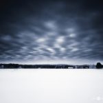 Dramatic Winter Sky Over Snow-Covered Landscape At Twilight