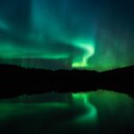 Green And Blue Aurora Borealis Over A Lake
