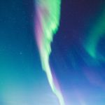 Green And Purple Aurora Borealis Illuminating The Sky