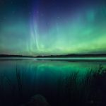 Green And Purple Aurora Borealis Over Body Of Water
