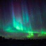 Green And Purple Aurora Borealis Illuminating Night Sky