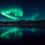 Green Aurora Borealis Over Lake At Night