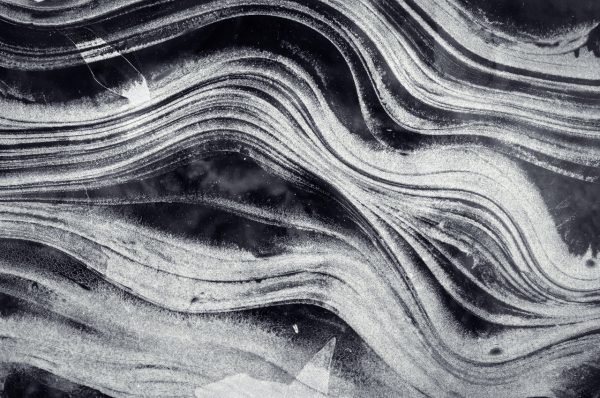 Intricate Patterns Of Frozen Ice On A Lake Surface During Winter