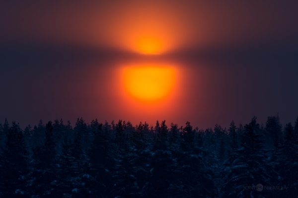 Sun Shining Through Clouds Over Forest
