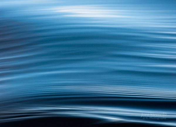 Tranquil Blue Water Ripples Reflecting Sunlight In The Calm Ocean
